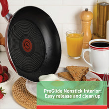 Red nonstick frying pan with black nonstick interior on a countertop
