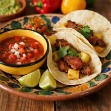 Tacos with chopped filling and salsa with lime on a decorative plate