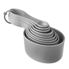 Stacked gray nesting measuring cups with handle