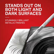 Fine-point metallic marker writing on dark surface, tip close-up