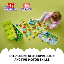 Child building with LEGO DUPLO bricks and figures on an open tray
