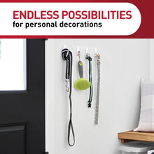 White Command wall hooks holding hanging keys and straps on a smooth wall