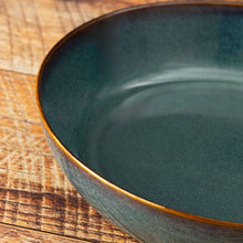 Teal ceramic serve bowl rim detail with glossy speckled reactive glaze