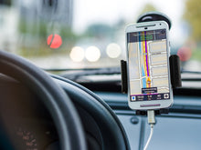 Universal dashboard phone mount holding a smartphone with suction base, black