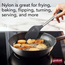 Hand holding dark gray nylon turner with stainless handle over a frying pan