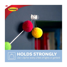 Clear Command clips holding pom garland on a wall