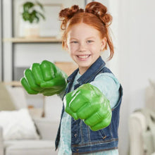 Child wearing green Hulk smash fist glove toy, fists raised