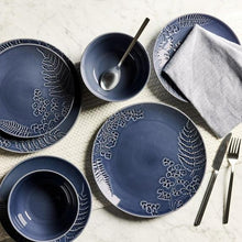 Blue stoneware dinnerware set with patterned plates, serving bowl, and spoon