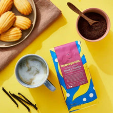 Smoky Vanilla ground coffee bag with a cup of dark coffee and ground coffee