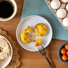 Golden steak and mushroom egg bites, one whole and one broken open on a plate