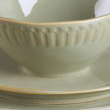 Green stoneware bowl rim with vertical ridges and speckled glaze
