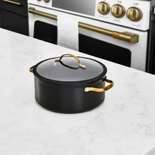 Black non-stick stock pot with glass lid and gold-tone side handles
