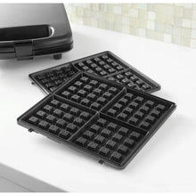 Black 4-slice waffle maker showing two waffle plates in open base