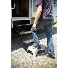 Gray plastic step stool with perforated top under a person stepping up