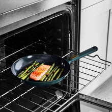 Nonstick fry pan on oven rack with asparagus and salmon inside