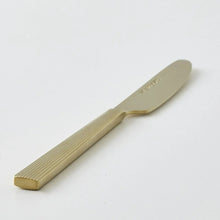 Gold stainless steel knife with ridged handle and smooth blade