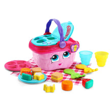 Pink toy picnic basket with purple handle, teal tray, and multicolor cups and shapes