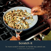Ceramic non-stick fry pan with sautéed vegetables being served with a utensil