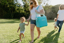 Igloo hard side cooler with carry strap, turquoise blue being carried outside