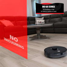 Black robot vacuum on light wood floor near couch and red sofa