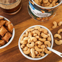 Whole cashews in bowl with spoon, salted nuts