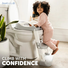 Toddler using a white potty training seat with splash guard and two-step ladder