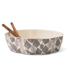 Leaf-pattern ceramic serving bowl with two wooden serving utensils, cream interior