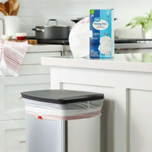 White drawstring tall kitchen trash bag on tabletop bin in a bright kitchen