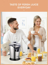 Electric citrus juicer on kitchen counter with stainless body and juice cups