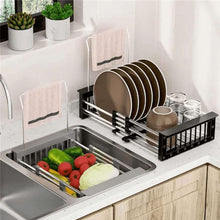 Over-sink dish drying rack holding plates, bowls, cups, and fruit over the sink