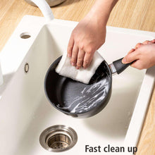 Black nonstick saucepan wiped clean with cloth for fast cleanup