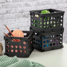 Two stacked black plastic storage crates with perforated panels and open tops