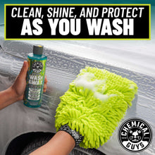 Wash & wax bottle and neon green microfiber mitt cleaning a car window surface
