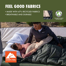 Doublewide sleeping bag with light interior and dark outer shell, shown during use