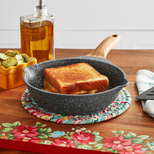 Charcoal speckle 8-inch fry pan with wooden handle holding toasted bread