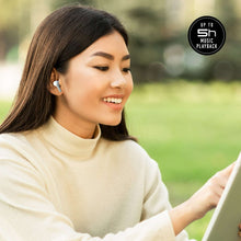 White true wireless earbuds in a woman’s ear while listening