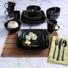 Black square dinnerware set with square plates, bowls, and mugs; flatware and napkins