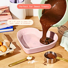 Pink heart-shaped stoneware baking dish filled with chocolate batter on a countertop