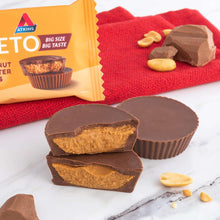 Dark chocolate peanut butter cups with sliced pieces on red cloth