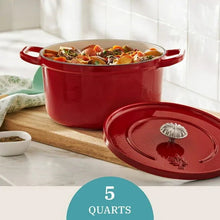 Red enamel Dutch oven with lid open, filled with vegetables and herbs