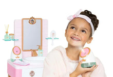 Child holding a green cup at a kids spa vanity with mirror and bottle accessories
