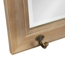 Metal coat hook detail on the bottom rail of a rustic wood wall mirror