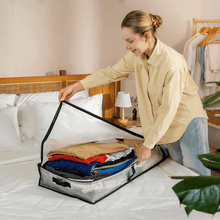 Clear under-bed storage bag with handles, open for storing folded items