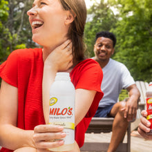Lemonade juice drink bottle held outdoors by person in red shirt