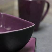 Purple serving bowl with dark interior and glossy stoneware finish
