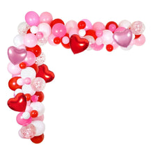 Heart-shaped balloon arch decoration with pink, white, and red balloons