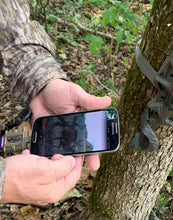 Smartphone with attached SD card reader accessory and tan-and-black clip