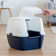 Navy and white enclosed cat litter box with front door flap lifted by hand