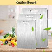 Brushed titanium cutting boards set with handle cutouts, with fresh produce on counter