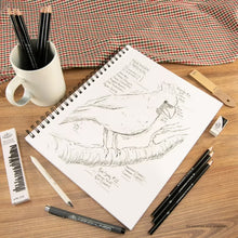 Sketching paper pad with spiral binding, open pages with pencil sketch and drawing tools